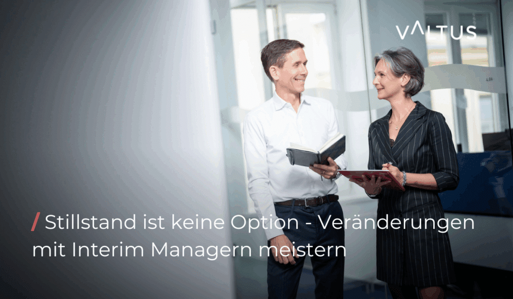 Zwei professionelle Interim Manager im Gespräch in einem modernen Büro, beide mit Notizbüchern – Textaufschrift: 'Stillstand ist keine Option – Veränderungen mit Interim Managern meistern', Logo von Valtus im Hintergrund.