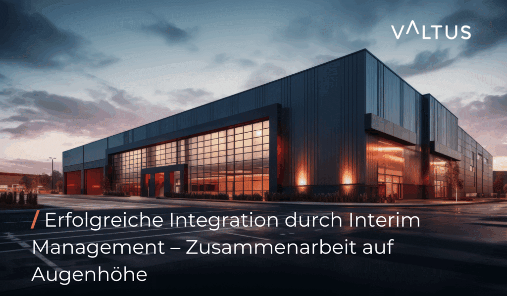 Moderne Industriehalle bei Sonnenuntergang, Glasfassade mit warmem Innenlicht, Symbolbild für erfolgreiche Integration eines Produktionsstandorts durch Interim Management – Valtus-Logo oben rechts